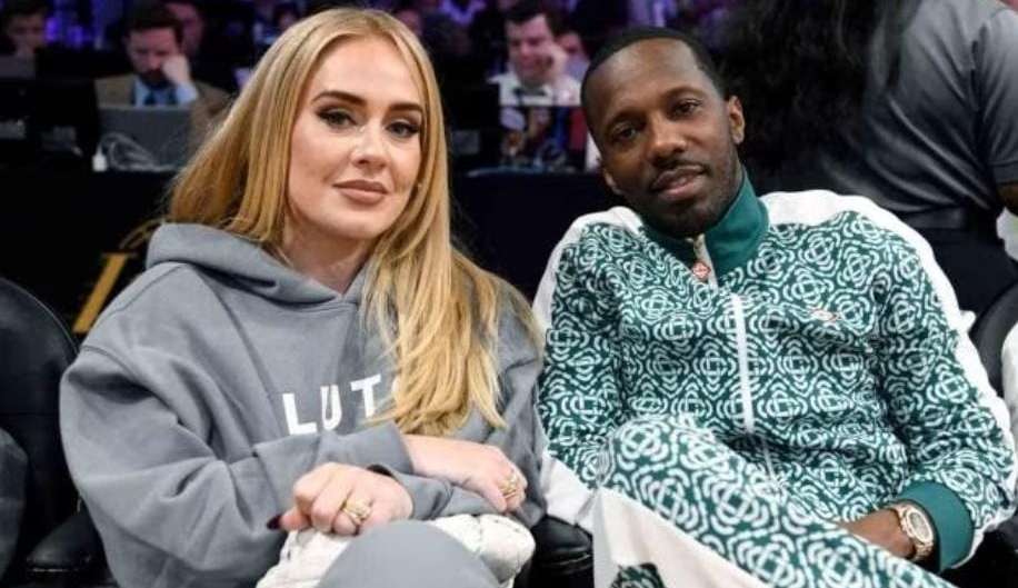 Sympathetic, Adele watches a basketball match next to her fiancé
