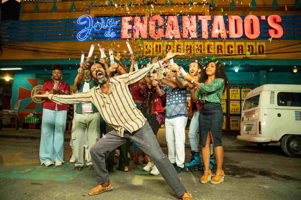 Eraldo (Luís Miranda) being surprised by all the employees bursting confetti on top of him in a scene from the series "Encantado's"